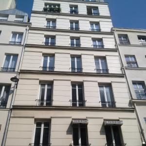 a tall white building with windows and balconies at Bridgestreet Le Marais - les halles - Republique in Paris