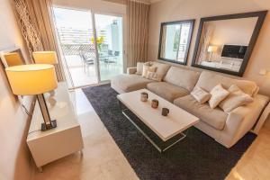 salon z kanapą i stołem w obiekcie VACATION MARBELLA I Brand New Terrazas de Banús Apt, 24-7 Security, a minute from the Marina, The Sea and Luxury Shopping w Marbelli