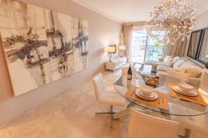 jadalnia ze szklanym stołem i kanapą w obiekcie VACATION MARBELLA I Brand New Terrazas de Banús Apt, 24-7 Security, a minute from the Marina, The Sea and Luxury Shopping w Marbelli