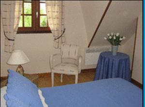 a bedroom with a blue bed and a table and chairs at Gîte La MER in Commes