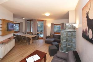 a living room with a couch and a dining room at Chalet Gondelblick in Zell am See