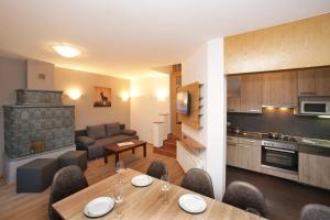 a kitchen and a living room with a table and chairs at Chalet Gondelblick in Zell am See