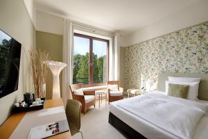 a bedroom with a bed and a desk and a window at Privathotel Lindtner Hamburg in Hamburg