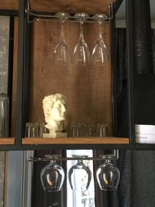 a shelf with wine glasses and a bust of a woman at Cozy Home in Old Tbilisi. in Tbilisi City