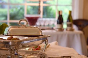 ein silbernes Tablett mit einem Teller Essen auf dem Tisch in der Unterkunft Simpson House Inn in Santa Barbara