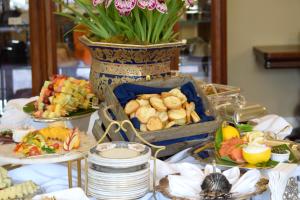 uma mesa coberta com pratos de comida e um vaso de flores em Simpson House Inn em Santa Bárbara