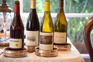 cuatro botellas de vino sentadas en una mesa en Simpson House Inn en Santa Bárbara