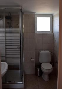 a bathroom with a toilet and a shower and a sink at Villa Oneiro in Kanali