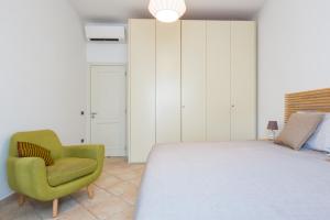 una camera con letto e sedia verde di Explore the Amalfi Coast from a Cosy Home in Sorrento Centre a Sorrento