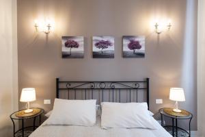 um quarto com uma cama com três pinturas na parede em Lucia's home em Florença