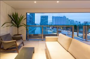 a living room with a couch and a large window at Studio Aconchego, próximo a Rua da Consolação, aos Metros República e Anhangabaú, com ar condicionado, piscina, academia, wifi e varanda in Sao Paulo