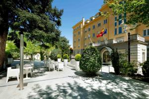 a courtyard with tables and chairs in front of a building at Exe Victoria Palace in San Lorenzo de El Escorial