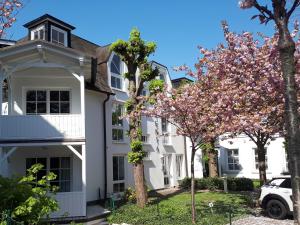 ビンツにあるAtelier-Appartement Ambienta im Zentrum von Binzの目の前に木々が植えられた白い家