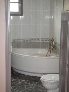 La salle de bains est pourvue d'une baignoire blanche et de toilettes. dans l'établissement Auberge des Lices, à Carcassonne