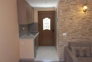 a kitchen with a brown door and a sink at Villa Birlis in Liapades