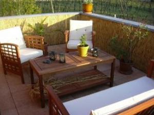 eine Terrasse mit einem Tisch, einem Stuhl und einem Couchtisch in der Unterkunft Vignoble in Bennwihr