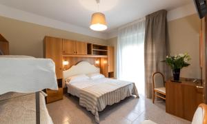 a hotel room with a bed and a window at Acapulco Beach in Lido di Jesolo