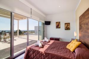 una camera da letto con un letto grande e un balcone di Villa Orquidea a Son Bou Altre 100 foto
