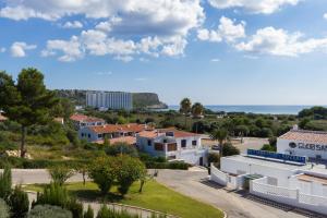 Vista ariale di una città con case e oceano di Villa Orquidea a Son Bou