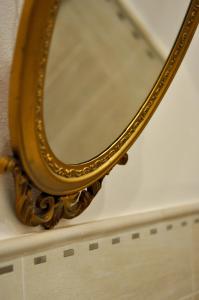 uno specchio d'oro su una mensola in una stanza di Le Macine Relais a Cairo Montenotte