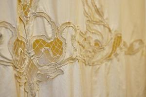 a white shower curtain with a gold design on it at Le Macine Relais in Cairo Montenotte