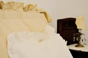 カイロ・モンテノッテにあるLe Macine Relaisの白いシーツを敷いたベッドの上