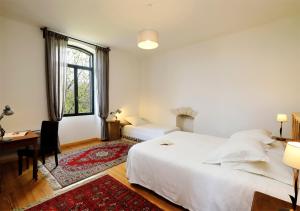 a bedroom with a bed and a desk and a window at l'ancienne gare in Gamarde-les-Bains