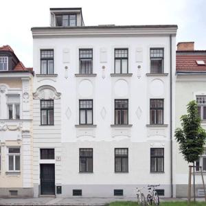 un edificio blanco con ventanas negras y un árbol en Ferienwohnungen Dr. Neubert, en Krems an der Donau