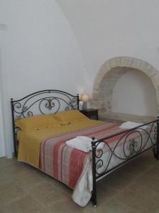 a bedroom with a bed with a red and yellow blanket at Masseria Ciavea in Gioia del Colle