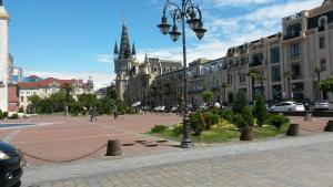 a city street with buildings and a clock tower at Tengiz`s Apartment on Gorgiladze in Batumi