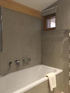 Das Bad ist mit einer Badewanne und einer Dusche ausgestattet. in der Unterkunft Mats Lech Alpenquartier in Lech am Arlberg