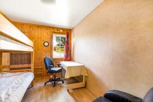 1 dormitorio con escritorio, 1 cama y ventana en Holiday Lakefront house en Björköby
