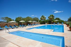 a large swimming pool with chairs and umbrellas at Agroturisme Na Martina in Portopetro +37 photos