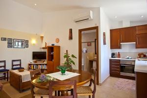 a kitchen and living room with a table and chairs at Agroturisme Na Martina in Portopetro