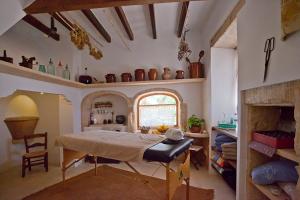 a room with a bed and a table and a window at Agroturisme Na Martina in Portopetro