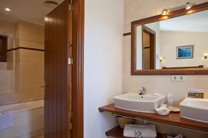 a bathroom with a sink and a mirror and a tub at Agroturisme Na Martina in Portopetro