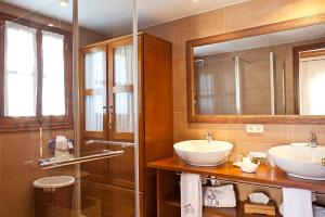 a bathroom with two sinks and a mirror at Agroturisme Na Martina in Portopetro