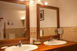 a bathroom with two sinks and a large mirror at Agroturisme Na Martina in Portopetro