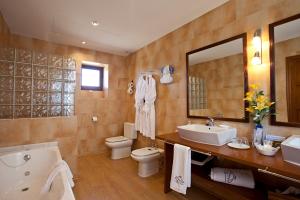 a bathroom with a tub and a sink and a toilet at Agroturisme Na Martina in Portopetro