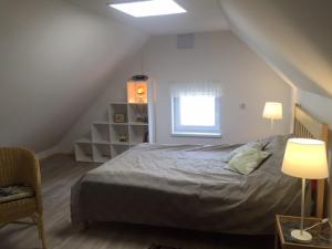 ein Schlafzimmer mit einem Bett, einem Stuhl und einem Fenster in der Unterkunft Samodzielny Dom Przy Lesie in Tereszewo