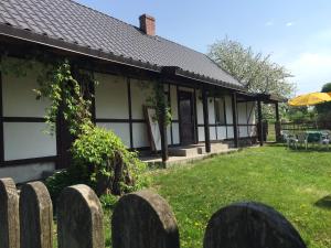 une maison avec une clôture devant elle dans l'établissement Samodzielny Dom Przy Lesie, à Tereszewo