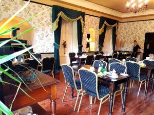 una sala da pranzo con tavoli e sedie e una donna sullo sfondo di Royal Spa Hotel a Lisdoonvarna