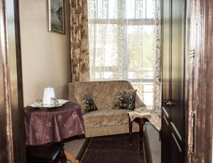 uma sala de estar com um sofá, uma mesa e uma janela em City Center Kaķis B&B em Sigulda