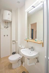 a white bathroom with a toilet and a sink at Casa Jerez Alameda del Banco in Jerez de la Frontera