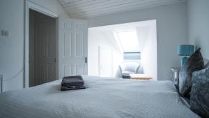 a white bedroom with a bed with a towel on it at Liberty Townhouses in Dublin