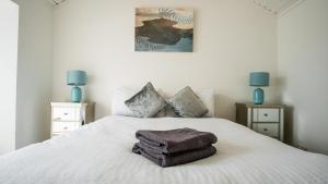 a bedroom with a bed with two towels on it at Liberty Townhouses in Dublin