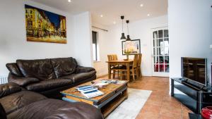 a living room with a leather couch and a table at Liberty Townhouses in Dublin