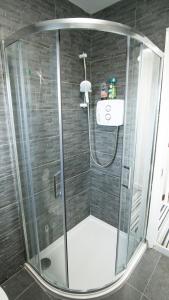 a shower with a glass enclosure in a bathroom at Liberty Townhouses in Dublin