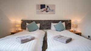 two twin beds in a room with two lamps at Liberty Townhouses in Dublin