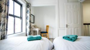 two twin beds in a room with a window at Liberty Townhouses in Dublin